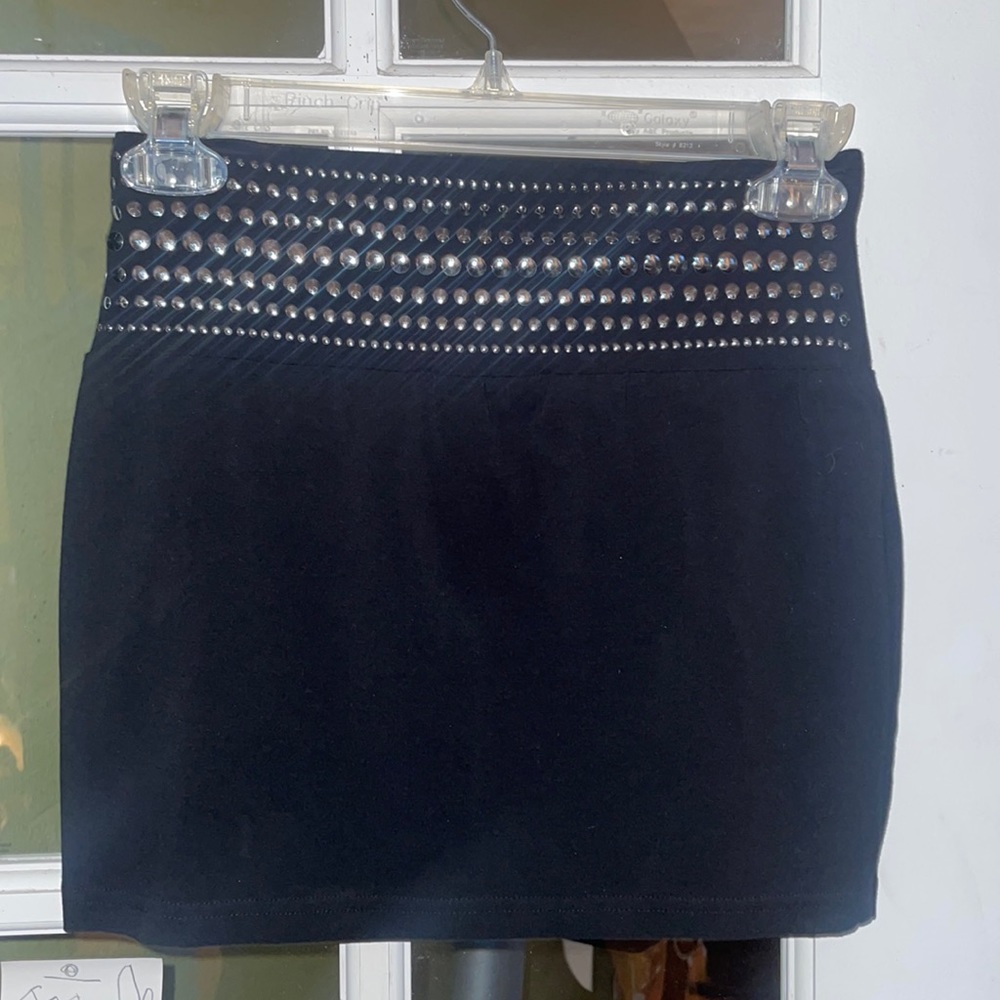 Black mini skirt with silver stud accents.
